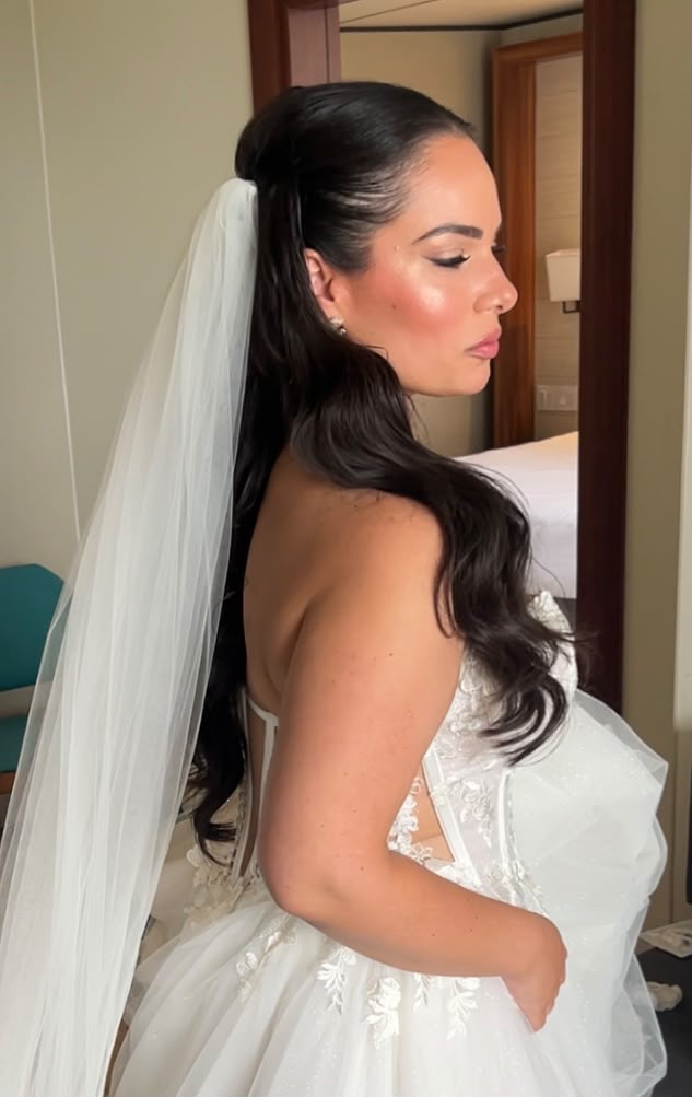Bride in profile with a long veil and soft wavy ponytail