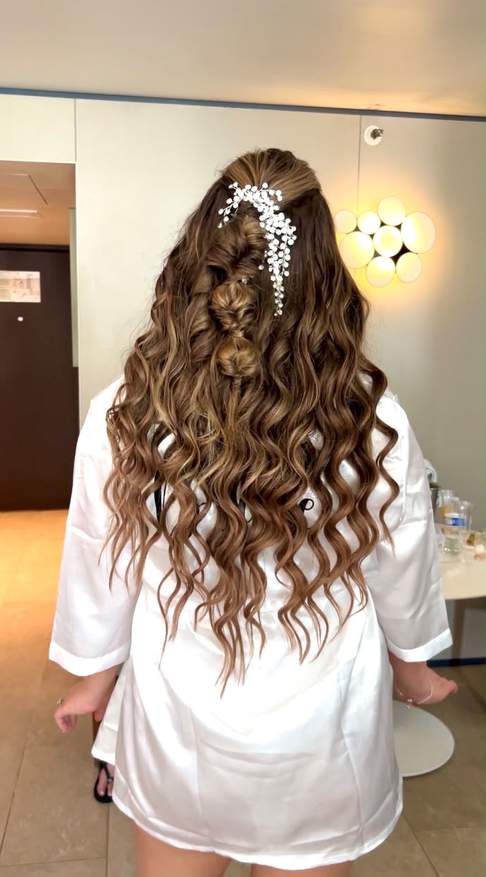 Half-up bridal style with loose curls and a crystal hair vine