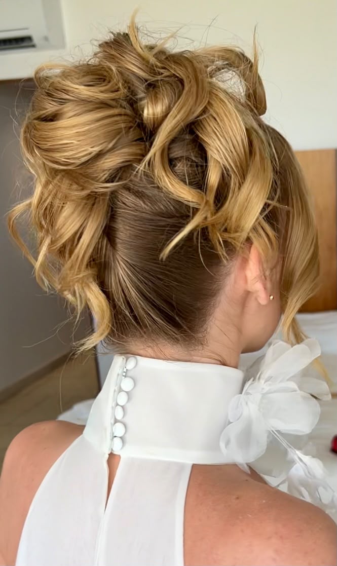 Voluminous curly blonde upstyle with soft tendrils