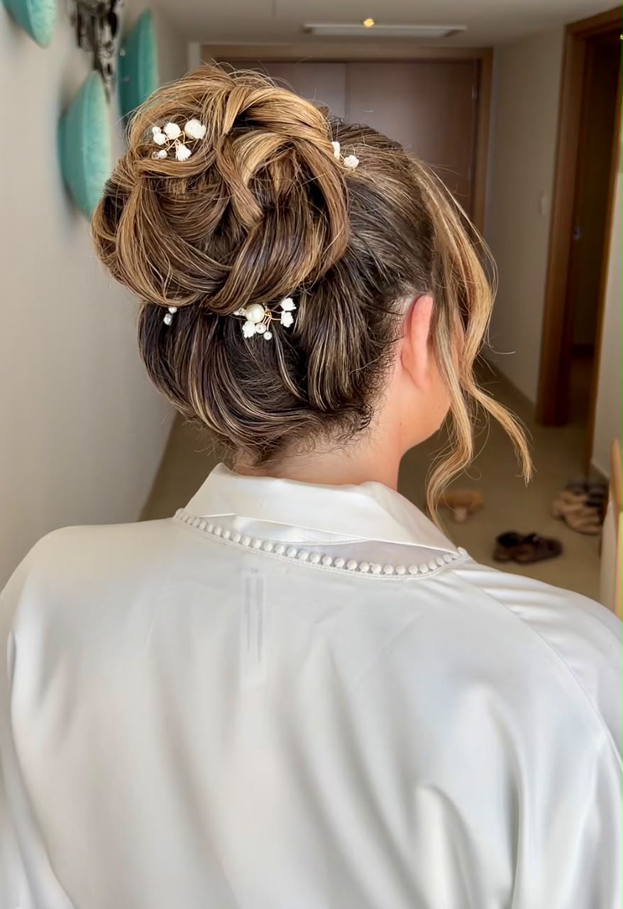 High textured bridal bun dressed with baby's breath pins