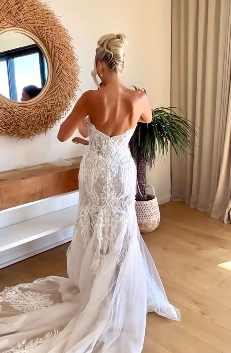 Blonde high bun updo with a lace wedding gown
