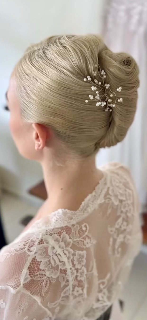 Blonde French twist finished with a pearl hair pin